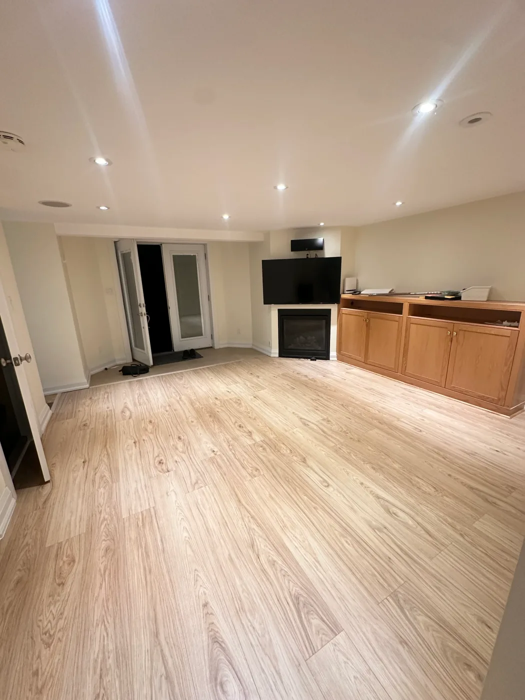 After: the same GTA room with the new light-wood laminate floor finished by Task Magic Handyman